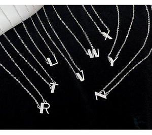 Detailed view of silver letter pendants R to Z with cubic zirconia pave on black background