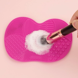 Pink silicone makeup brush cleaning mat with suction cup and diverse textures