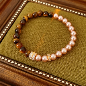 Detail of tiger eye and pink pearl beaded bracelet in a vintage display box