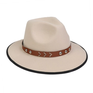 Detail of beige fedora with brown leather band, silver rivets, and black bound edge brim