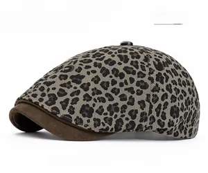 Detail of grey leopard print flat cap with brown suede brim and textured fabric