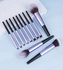 Détail d'un kit de 12 pinceaux de maquillage violet et noir sur fond bleu clair