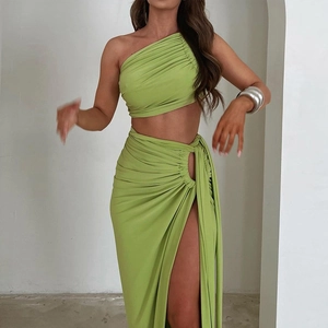 Detail of green two-piece set featuring one-shoulder crop top and ruched high slit skirt