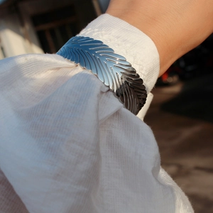 Dettaglio della trama del bracciale a piuma d'argento con venature metalliche fini