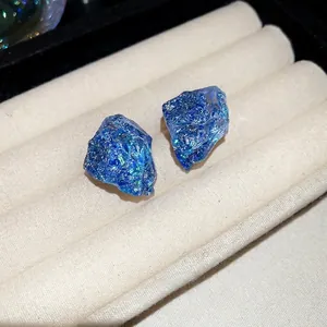 Macro shot of bright blue irregular resin studs with sparkling glitter on a velvet tray