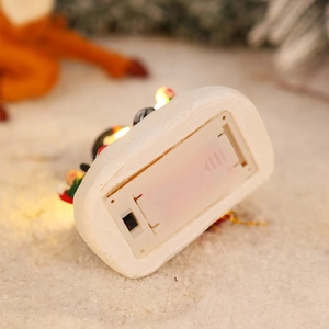 Detail view of the glowing Christmas resin house base with battery compartment and switch