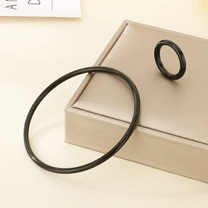 Macro shot of black minimalist ceramic finish stainless steel bangle and ring set