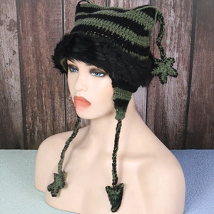 Detail of hand-knitted cat ear hat with green stripes and star-shaped pendants