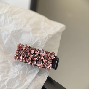 Gros plan d'une petite barrette à cheveux ornée de strass roses étincelants