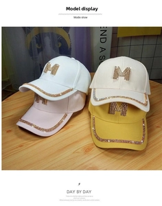 Detail of multi-color cotton baseball caps with crystal M logo and rhinestone brim accents