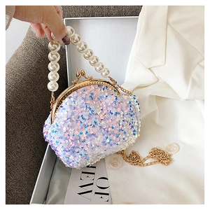 Detailed shot of sequin seashell bag featuring pearl handle and gold clasp closure