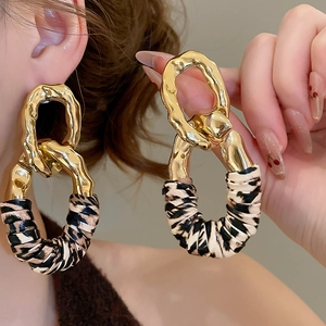 Retro gold hammered metal chain link earrings with leopard print fabric detail on model