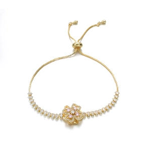 Detail of adjustable golden slider bracelet with floral zircon pendant and colorful stones