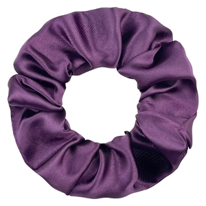 Detailed view of dark purple satin scrunchie showing smooth fabric texture and folds