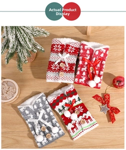 Detail of knitted Christmas wine bottle covers with reindeer, snowflakes and pom-poms