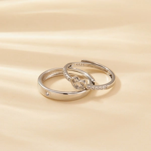 Macro shot of S925 sterling silver couple rings with heart cutout and zircon inlay