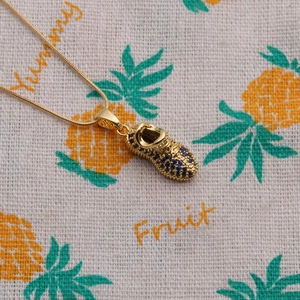 Golden sneaker pendant necklace with sparkling blue and clear crystals on a chain