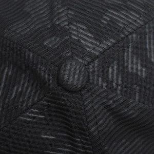 Macro shot of baseball cap top button and detailed reinforced stitching on black fabric