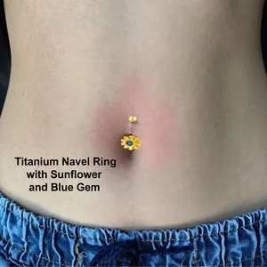 Golden daisy belly button ring with deep blue gemstone inlay shown on navel