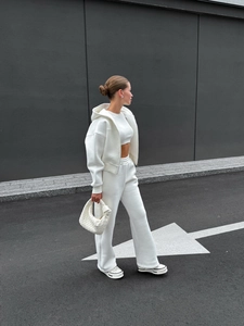 Survêtement blanc à capuche trois pièces et sac à main en cuir tressé en milieu urbain