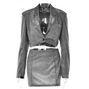 Détail du tissu pailleté argenté sur l'ensemble deux pièces blazer court et mini-jupe