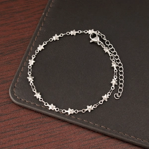 Detailed shot of a silver star chain bracelet with adjustable lobster clasp on leather