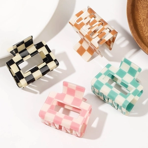 Set of four checkered square hair claws in black, amber, pink, and green colors
