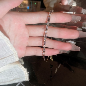 Detail of adjustable rose gold bracelet with purple zircon and white crystal stones