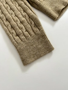 Detailed close-up of khaki V-neck polo knitwear featuring classic twist texture and ribbed cuffs