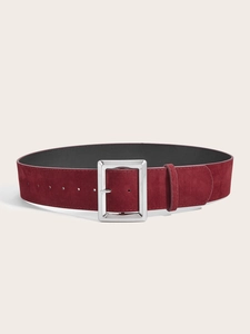 Détail d'une large ceinture en daim bordeaux avec surface texturée et boucle argentée