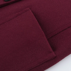 Close-up of thick wine red wool blend fabric texture and stitching detail on winter coat
