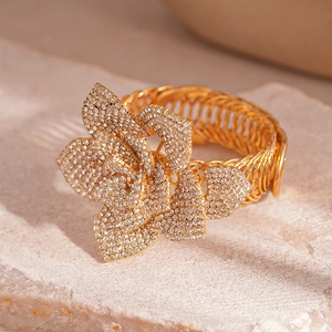 Detailed macro view of gold-tone geometric flower bracelet with sparkling rhinestones