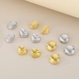 Makroaufnahme verschiedener Herz-, Rund- und Textur-Ohrringe aus Gold und Silberstahl