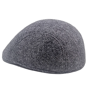 Close-up of grey herringbone wool texture and thick fabric on winter beret flat cap