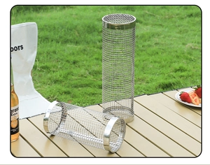 Detail of cylindrical stainless steel rolling grill baskets on a wooden outdoor table
