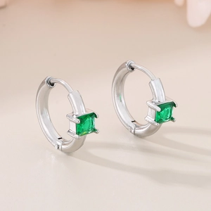 Macro view of silver quadrilateral hoop earrings with square green emerald glass stones