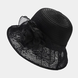 Detail of elegant black sun hat showing spiral weave and floral lace brim with organza flower