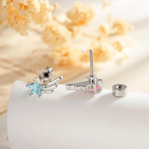 Star zircon wing stud earrings with blue and pink gems on white display stand