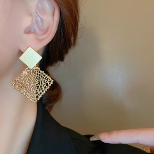 Detail of vintage square mesh geometric earrings with matte gold finish on model