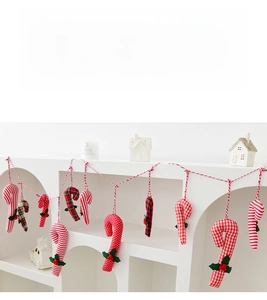 Close-up of fabric Christmas candy cane ornaments with red berries and plaid patterns