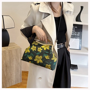 Detail of green Cheongsam bag with yellow floral embroidery and bamboo handle