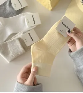 Detail of combed cotton socks with vertical stripes in pastel Morandi colors
