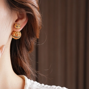 Gros plan de boucles d'oreilles vintage dorées 18k avec pierres de zircon colorées