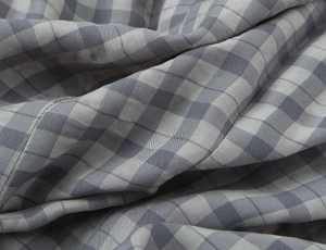 Macro view of grey and white gingham fabric texture showing the twill weave detail