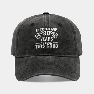 Detailed view of black washed cotton baseball cap with white 80th birthday embroidery