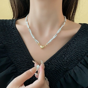Detail of double-layer faux silver and pearl necklace with golden heart magnetic pendant