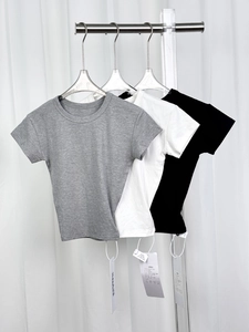 Detailed view of gray, white, and black modal t-shirts on hangers with quality tags