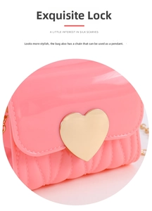 Detail of a pink mini jelly bag featuring a golden heart-shaped lock and chain strap
