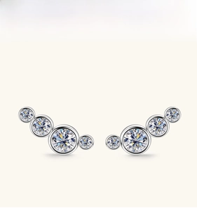 Detail of curved silver ear climbers with gradient moissanite stones in a minimalist design