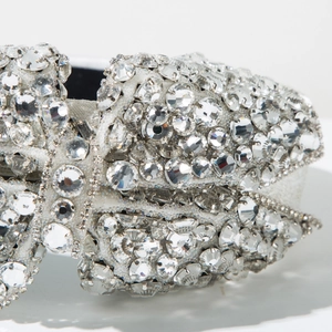 Détail d'un serre-tête de luxe avec strass étincelants, design nœud et base en métal argenté